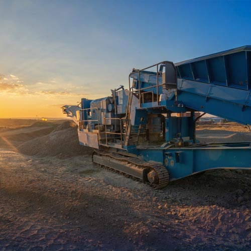 A large blue machine is parked on the dirt.