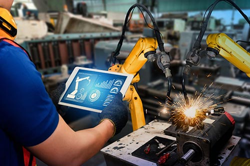 A person holding an ipad in their hand while welding.