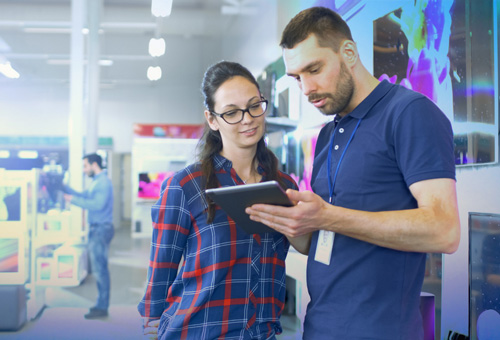 A man and woman looking at an ipad.