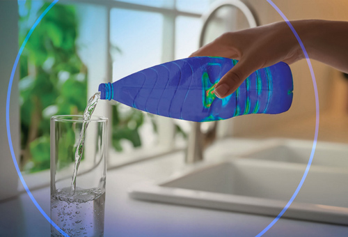 A person pouring water into a glass from a bottle.