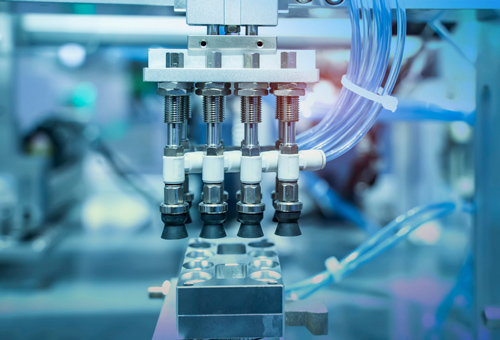 A machine with many valves and pipes in the background.