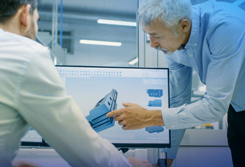 A man holding something in front of a computer screen.