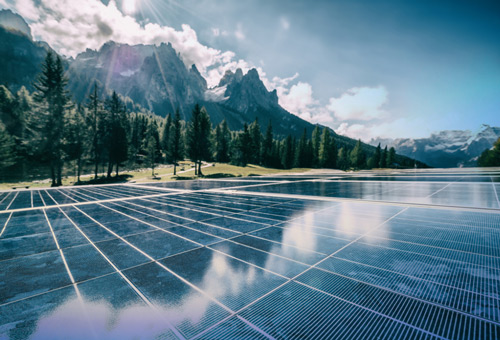 A large solar panel sitting in front of some mountains.