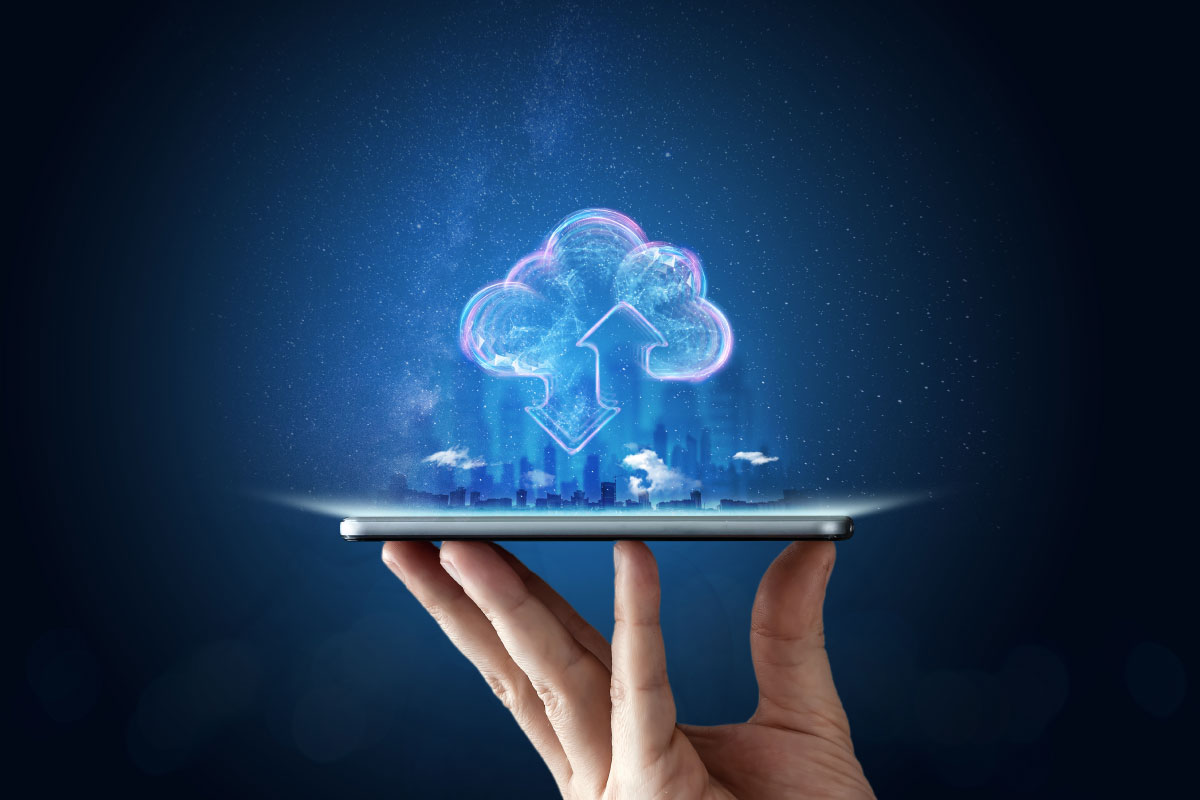 A hand holding an ipad with a blue cloud on it.