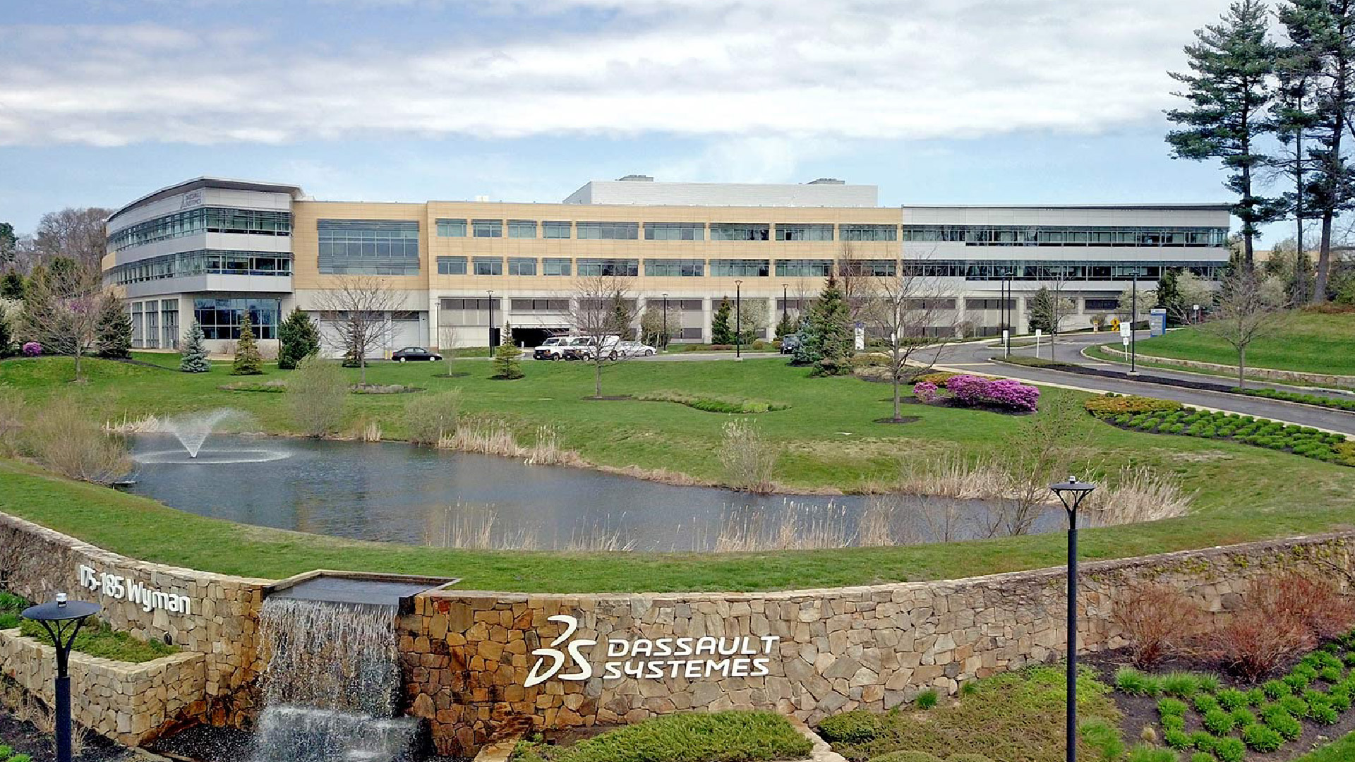 A large building with grass and water in front of it.