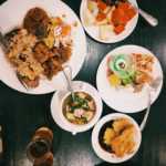 A table with plates of food and drinks on it.
