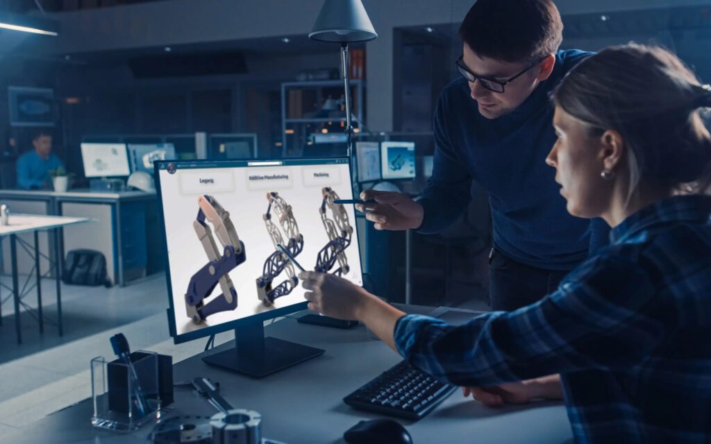 Two men looking at a computer screen with images of hands on it.