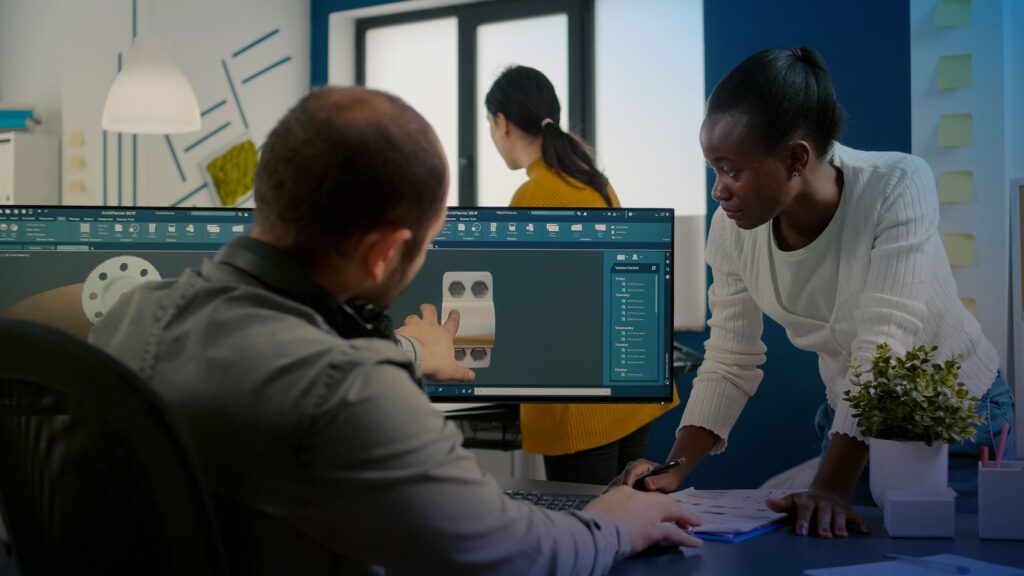 Two people working on a project in front of a computer.