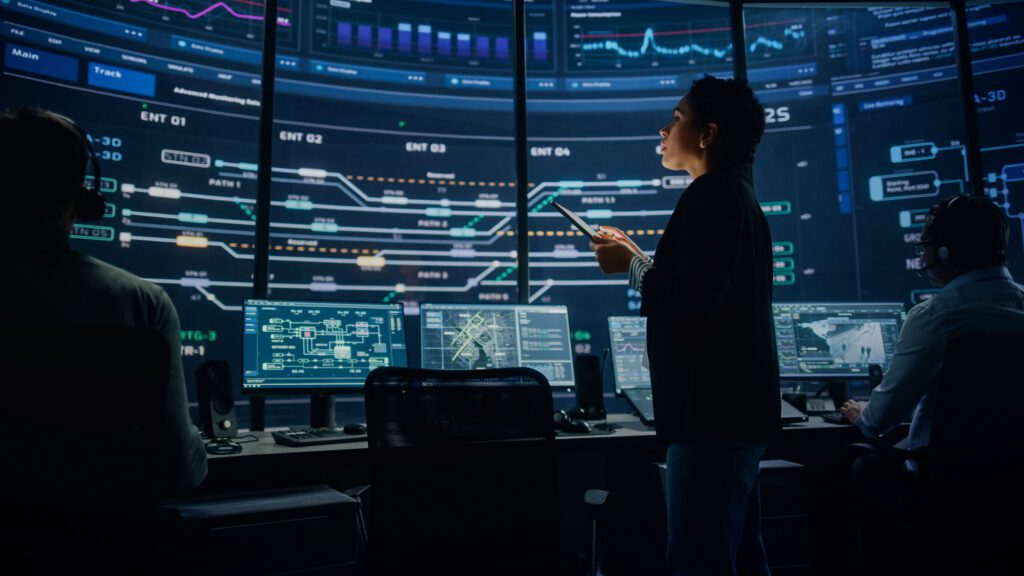 A person standing in front of a large monitor.